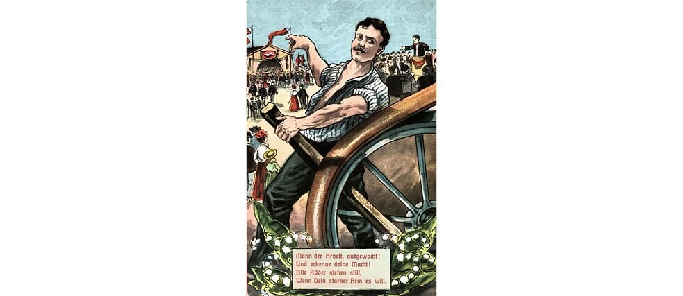 A detail of a historical postcard showing a man’s muscular arm stopping a large wheel