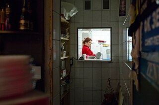 Die Besitzerin des russischen Pubs „Derevyashka” in Kopli, einem Stadtteil Tallinns. Tagsüber serviert sie ihren Gästen selbstgemachtes russisches Essen, nachts mimt sie den DJ. Kopli, Tallinn, 2016