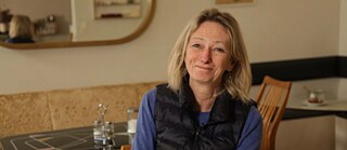 Maureen (blonde Frau) schaut lächelnd in die Kamera