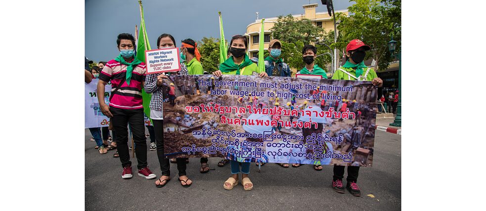 1. Mai 2022 in Bangkok, Thailand: Wanderarbeiter*innen halten während eines Protests ein Transparent, auf dem sie ihre Meinung zum Ausdruck bringen. 