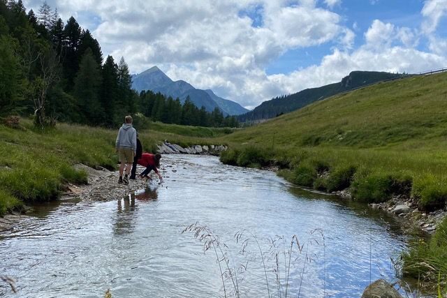 Jugendliche am Ufer eines Baches