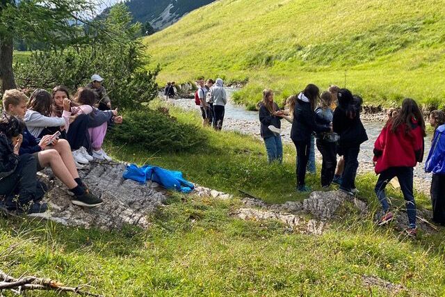 Jugendliche am Ufer eines Baches