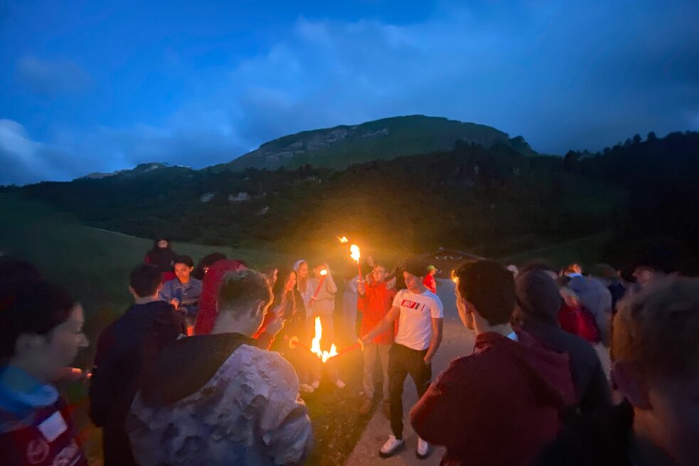 Jugendliche mit Fackeln in den Bergen