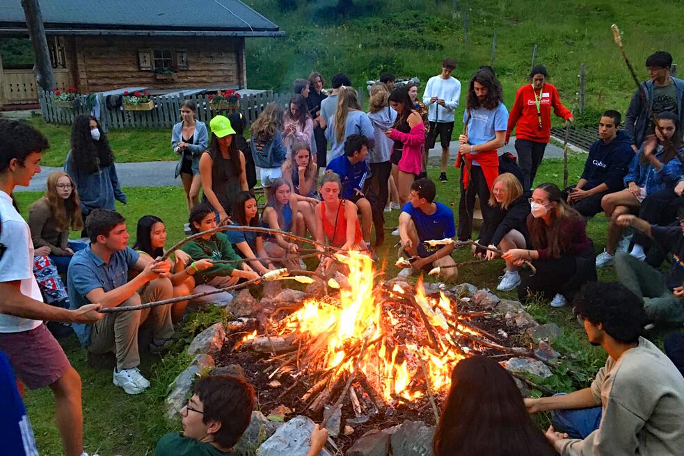 Jugendliche garen Marschmellows über dem Feuer.