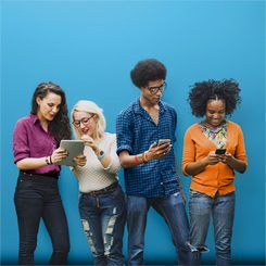 quatro jovens olham seus celulares e interagem entre si