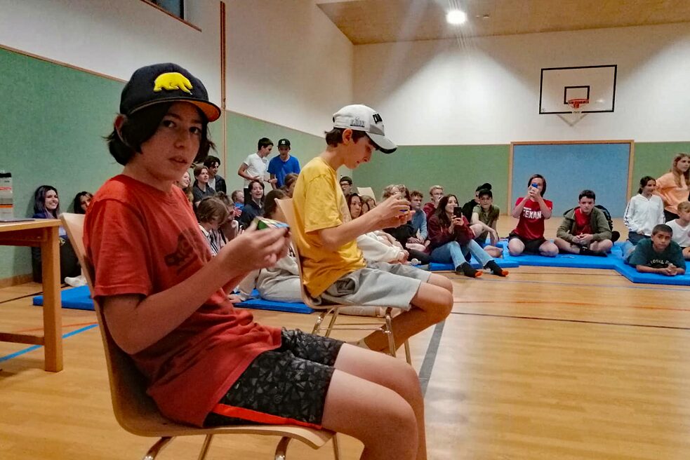 Jugendliche auf Stühlen.