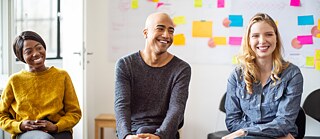 Young entrepreneurs in a meeting, laughing.