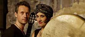 Musiker*innen mit Gitarre und Riesentamburin: Silvio Schneider und Karolina Trybała