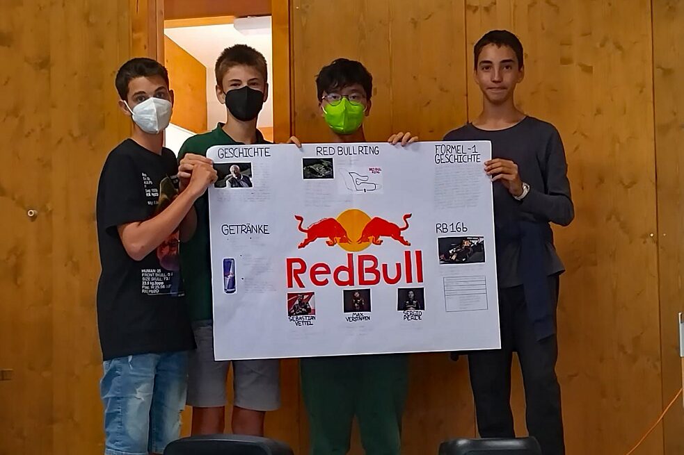 Jugendliche präsentieren ein Plakat.