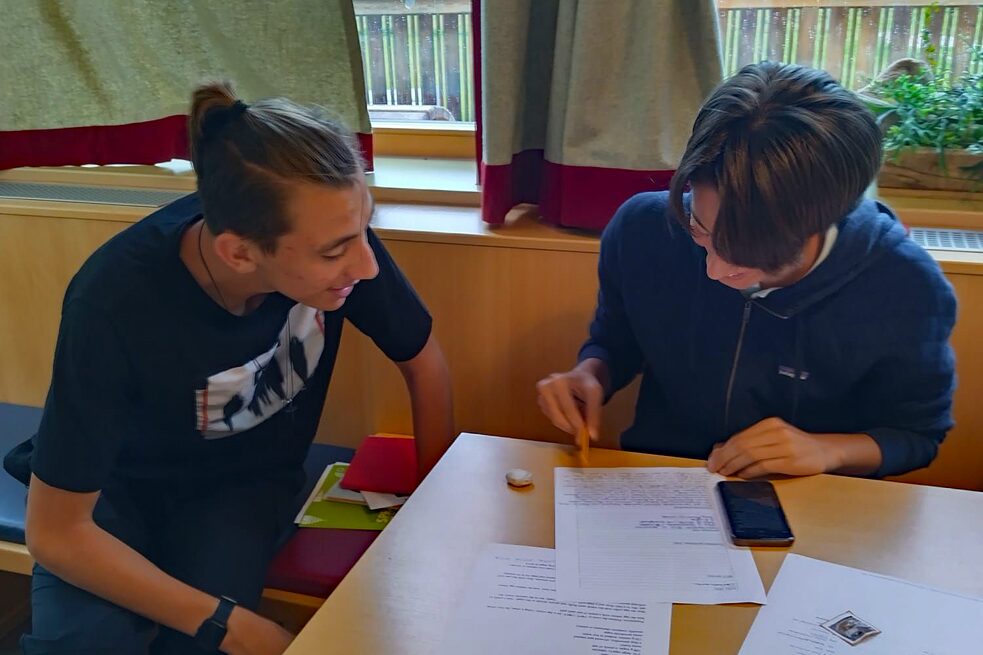 Jugendlicher arbeiten an einem Tisch an ihren Projekten.