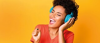 Woman singing along wearing headphones