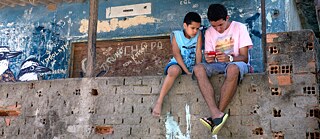Kinder Spielen in der Favela mit einem Computerspiel