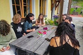 Jugendliche knüpfen Freundschaftsbänder.