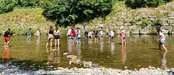 Jugendliche baden in einem Fluss.