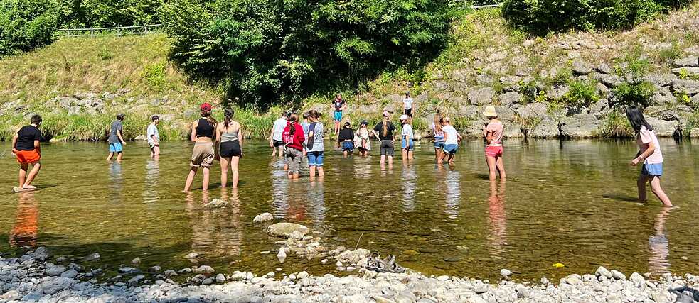 Jugendliche baden in einem Fluss.