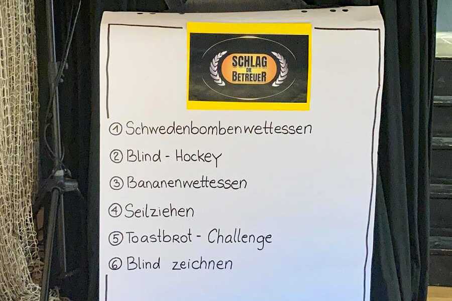 Eine Flipchart auf der die Überschrift „Schlag den Betreuer“ und die Disziplinen stehen.