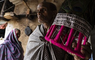 The mukut or headgear stand as a strong cultural emblem for the Ramnamis, constituting their religious identity. The helm is painted with bright colours with a white piece of cloth tied around it that mentions the name of Ram in repetition. On top, a flock of peacock feathers signify its rich mythological connotation.