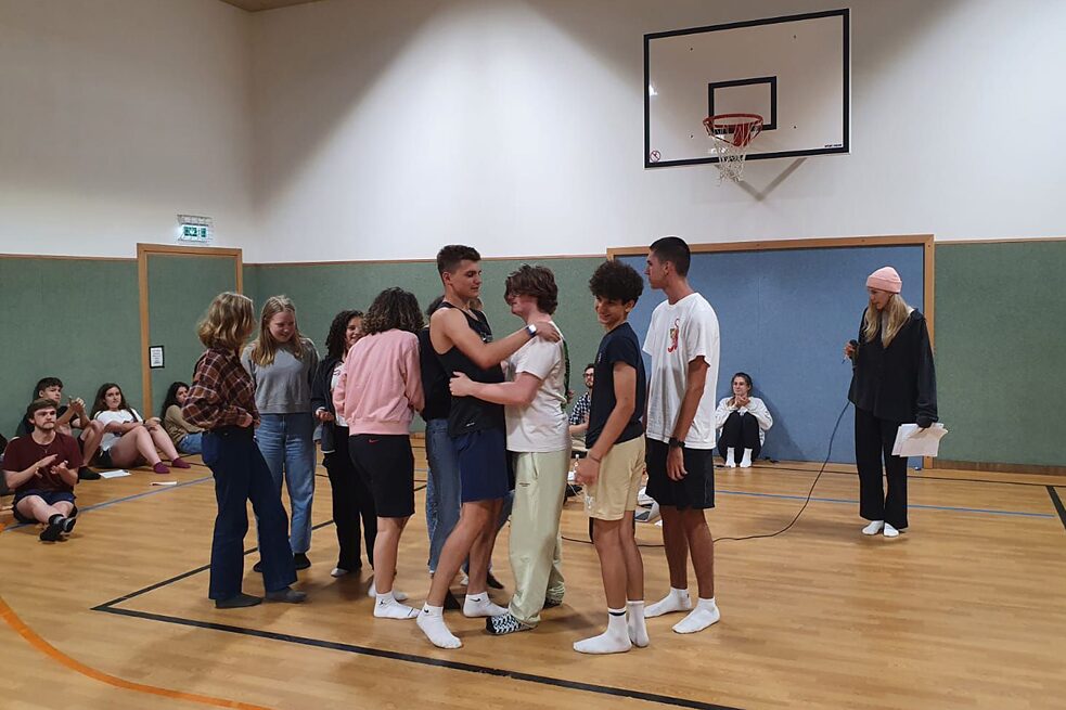 Jugendliche in einer Sporthalle.