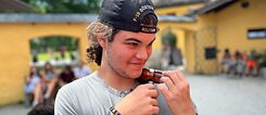 Jugendlicher spielt auf einer Miniatur-Geige