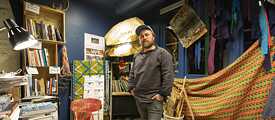 Joar Nango inmitten der Bücherregale der Girjegumpien in Karasjok. 