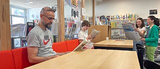 Deux hommes et deux femmes lisent et parlent entre eux autour d'une grande table avec du café &copy; © Antje Lempart-Ober, Goethe-Institut Lyon Café Bibliothèque Goethe-Institut Lyon