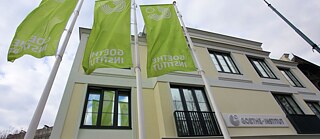 Fassade des Goethe-Institus in Sarajevo mit wehenden Flaggen mit grünem Logo des Goethe-Instituts
