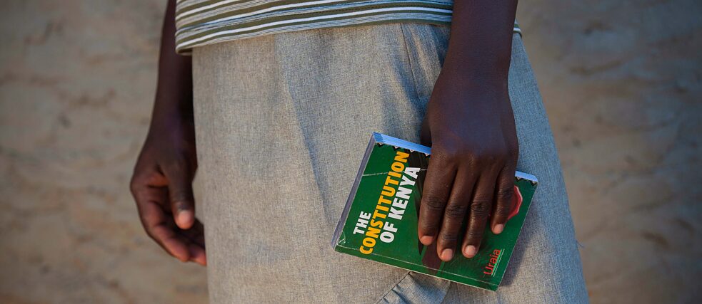 Jemand hält eine Ausgabe der 'The Constitution of Kenya' in der Hand