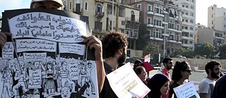 Un groupe de personnes dans une rue de Beyrouth brandissant des affiches critiquant la mauvaise gestion du gouvernement et la crise des ordures ménagères en 2015.