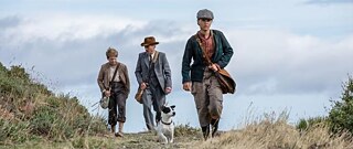 Ein Mann, ein Junge und ein Mädchen gehen einen Pfad entlang.