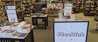 Wenn die digitale Bücherwelt in die analoge übergeht: Millionen von Leser*innen besprechen Bücher auf TikTok. Deren Empfehlungen landen dann wiederum auf den Büchertischen der Buchhandlungen. 
