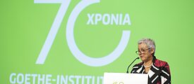 Die Präsidentin Carola Lentz steht an einem Rednerpult. Hinter ihr auf der Leinwand steht „70 Jahre Goethe-Institut“