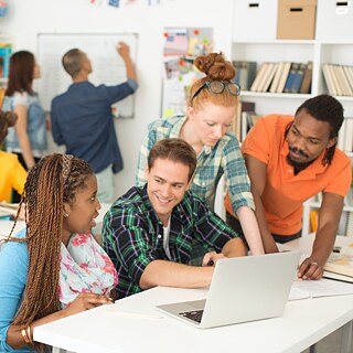 zwei Lehrkäfte unterhalten sich mit Schülern