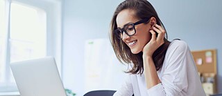 Frau vor einem Computer sitzend