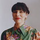A portrait photo by Małgorzata Mirga-Tas of a dark-haired woman in a colourful blouse 