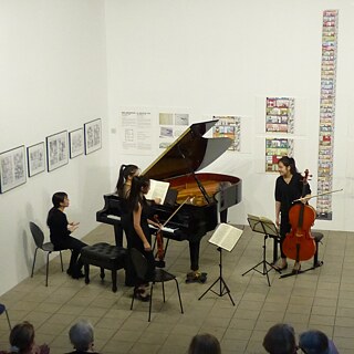 Quatre musiciennes autour d'un piano dans une exposition