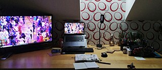 Stůl s obrazovkou, notebookem a psacími potřebami. © © Ellen Marie Groening Weltenschreiber