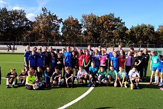 Gruppenfoto der Teilnehmenden auf dem Fußballplatz