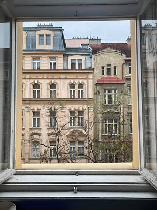 "Aus meinem Fenster sehe ich diesen altbauwohnungen. Ich wohne in Vinohrady, das ist ein Stadteil von Prag. Wir haben viele Parks hier, also das ist schön.  Prag hat cca. 1,3 milionen Einwohner.  Ich fahre etwa 45 Minuten nach der Schule. Aber es ist nicht so schlecht. Ich fahre mit meine Freundin, oder ich lese mein Buch oder ich Schulsachen  machen."