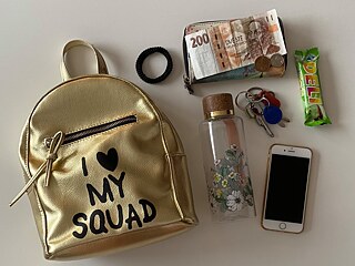 In meiner Tasche trage ich einen Getränk, eine Geldbörse, die Schlüssel, ein Handy, ein Haargummi und Kleinigkeit zum Essen.
