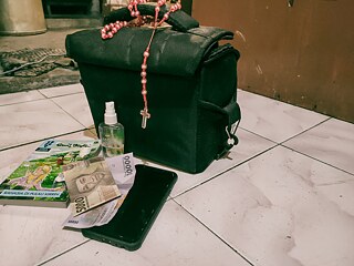Ich trage den Rosenkranz in meiner Tasche. Meine Mutter sagte, ich müsse es immer bei mir tragen. Während dieser Pandemie habe ich immer ein Händedesinfektionsmittel bei mir. Dann brauchte ich auch Geld auf Reisen, also brachte ich es mit. Ich lese gern, deshalb habe ich immer Bücher bei mir. Natürlich werden Handys nie zurückgelassen. Es ist sehr wichtig, ein Handy mitzubringen, um jemanden zu kontaktieren oder interessante Objekte zu fotografieren.