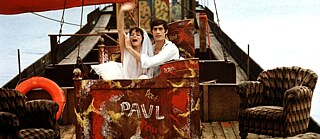 Szenebild aus ‚Die Legende von Paul und Paula‘. Paul und Paula schippern auf einem Kahn die Rummelsburger Bucht in Berlin runter