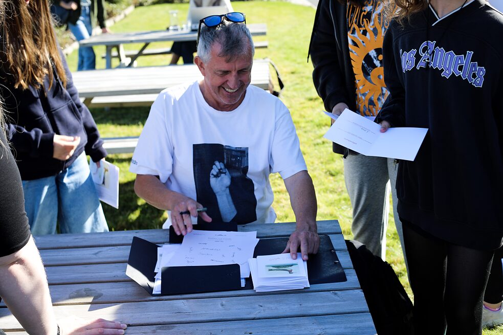 Wolfgang Müller handing out certficates during the workshop 'What nationality do birds have?', taking place outside of the Nordic House. 