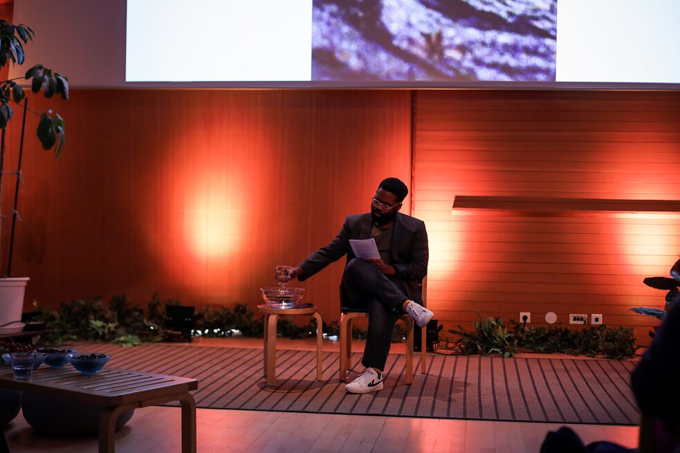 hn.lyonga on a chair in front of the audience, pooring water