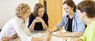 Junge Leute im Unterricht, am Tisch