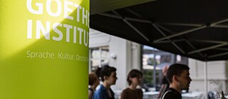 Grüne Säule auf der das Logo des Goethe-Instituts zu sehen ist