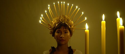 A headdress made of burning candles creates light but looks dangerous