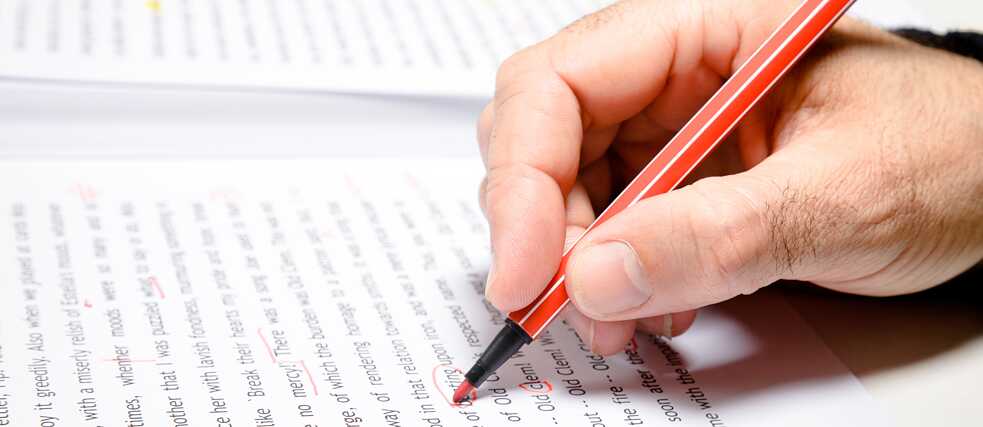 Hand mit Rotstift korrigiert Text