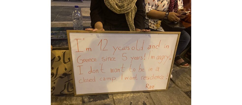 Mädchen mit Schild, das gegen den Aufenthalt in einem Lager protestiert