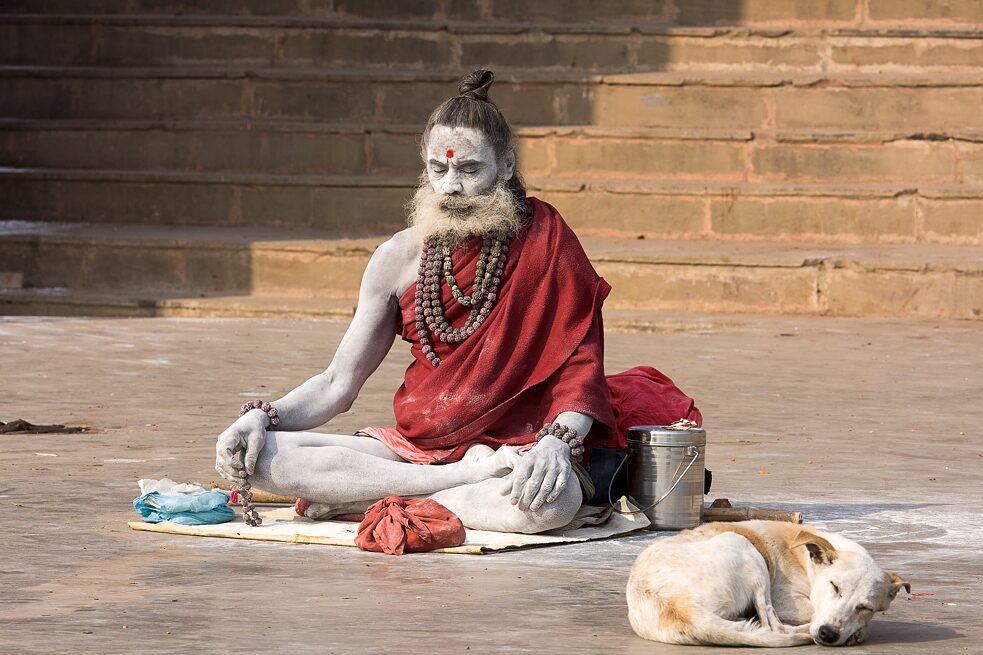 An ash-smeared Naga sadhu seated in meditation