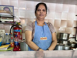 A woman stands behind the counter of the snack bar and looks into the camera